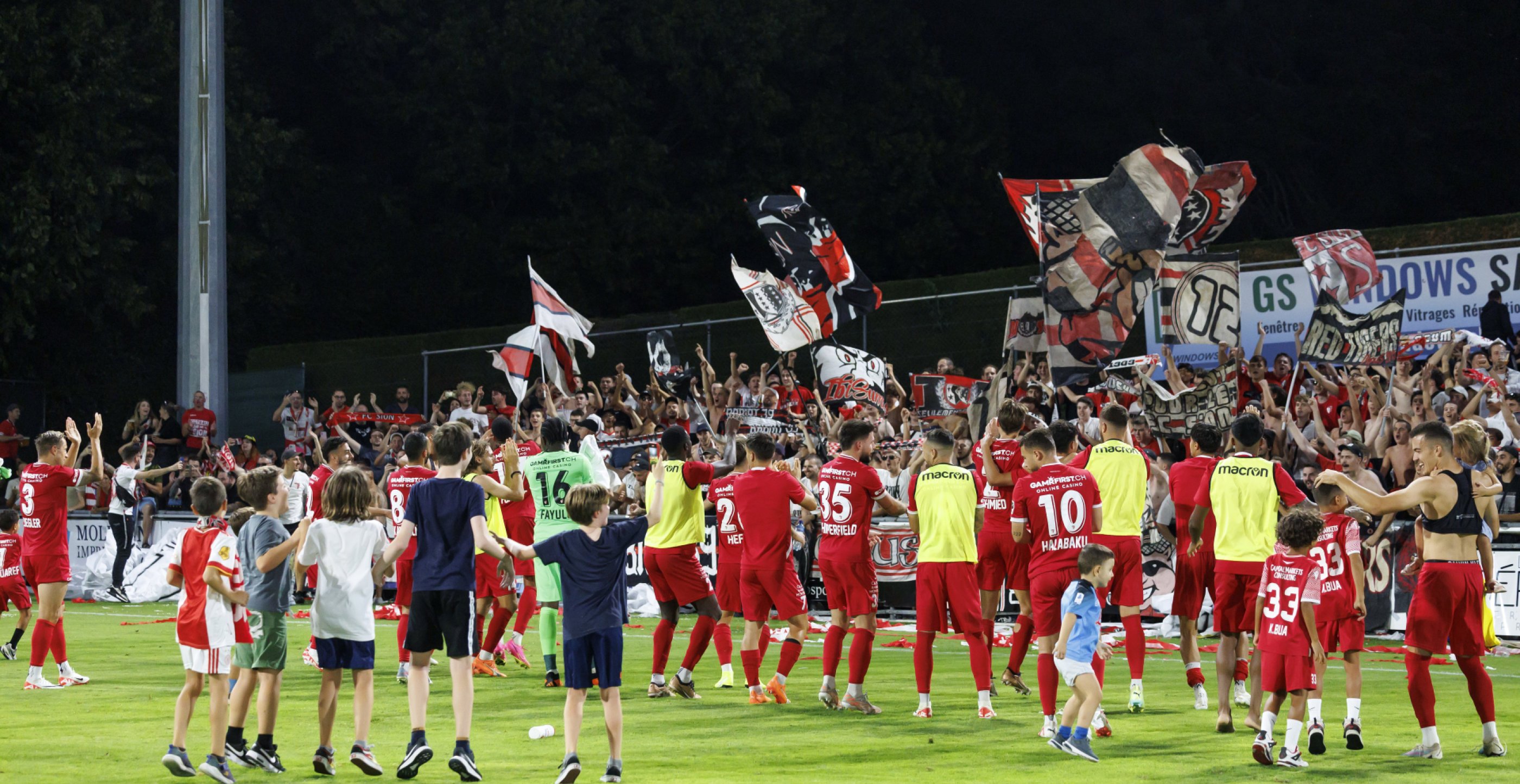 Sion's players celebrate with supporter after defeating the team Stade Nyonnais, during the Challenge League soccer match of Swiss Championship between FC Stade Nyonnais and FC Sion, at the Stade de la Colovray, in Neuchatel, Switzerland, Friday, August 25, 2023. (KEYSTONE/Salvatore Di Nolfi)